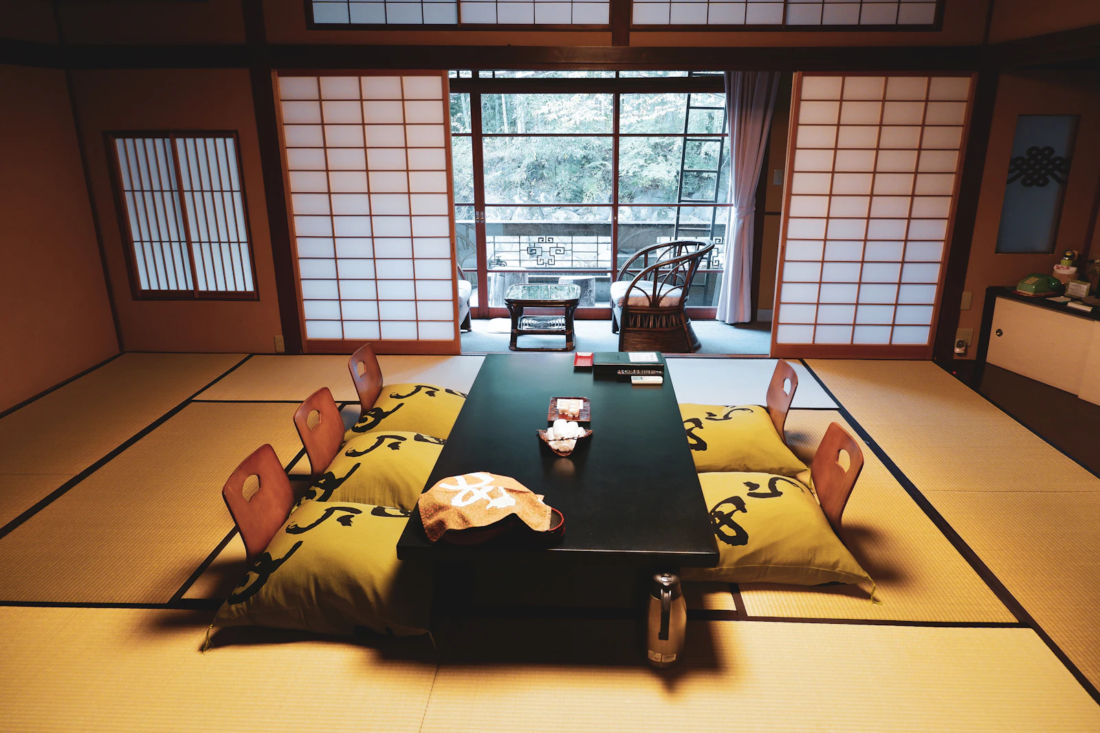 Quarto de ryokan japonês com tatame, mesa baixa e portas shoji